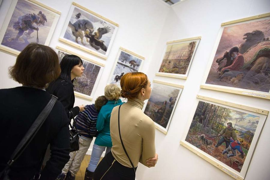 Посетители рассматривают картины на художественной выставке